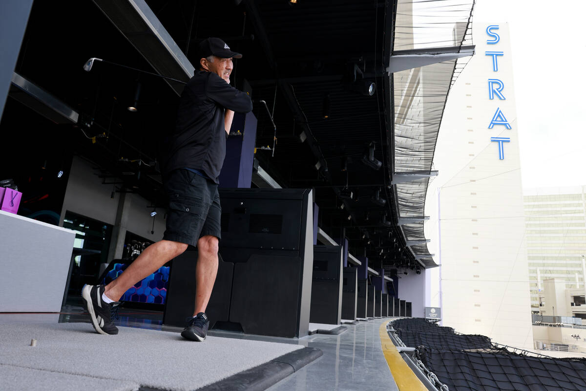 Raymond Suda hits from a fourth floor bay at Atomic Golf adjacent to The Strat in Las Vegas dur ...