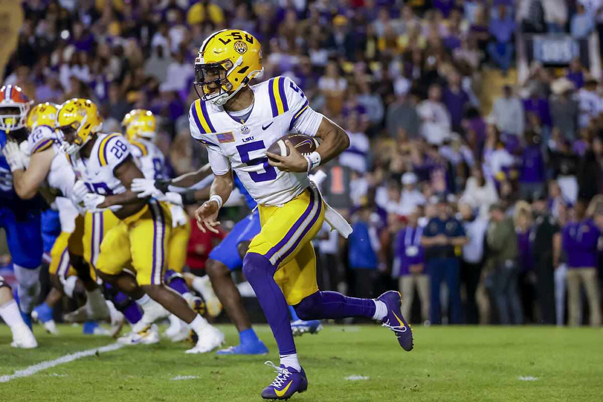 FILE - LSU quarterback Jayden Daniels (5) runs for a touchdown against Florida during the first ...