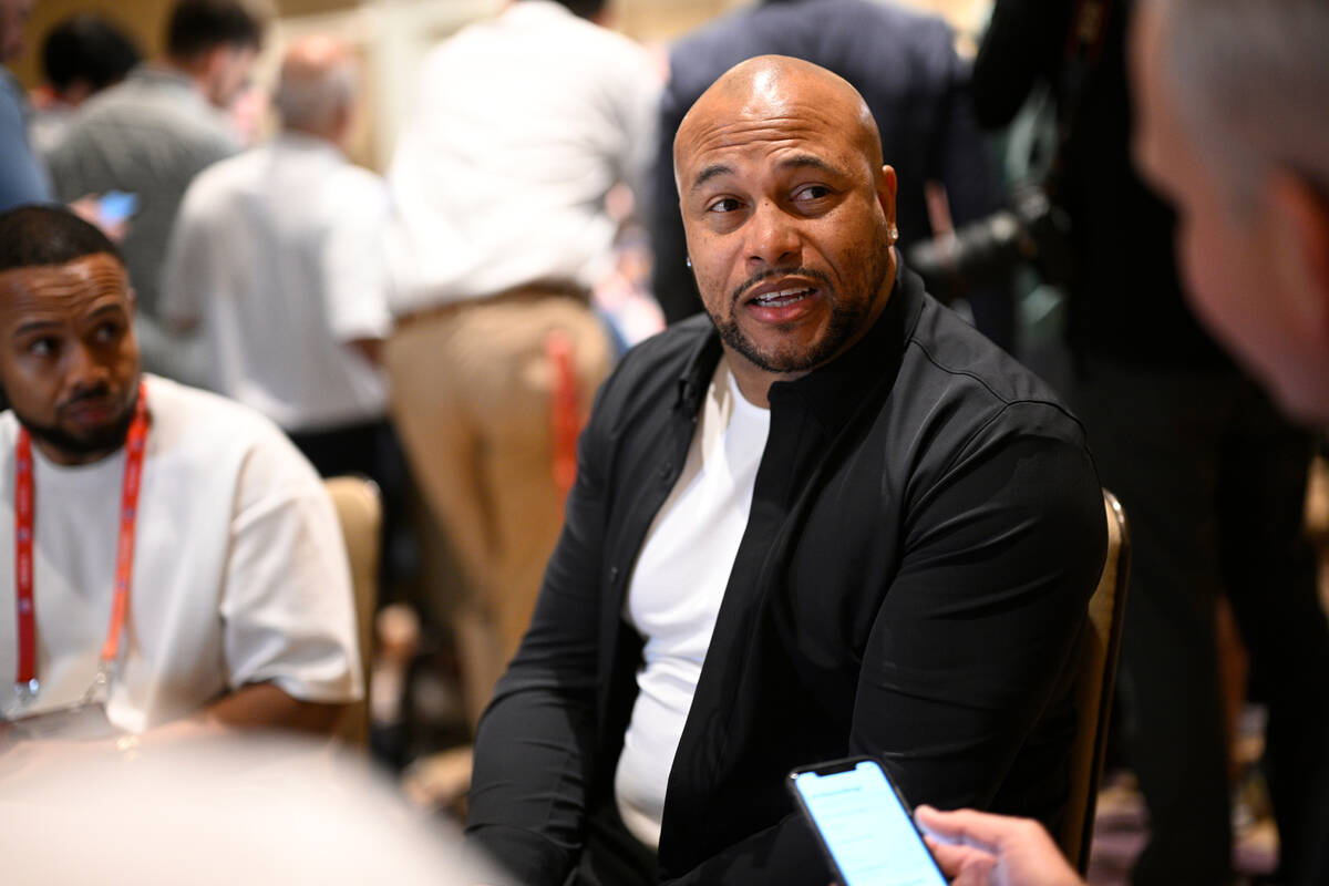 Las Vegas Raiders head coach Antonio Pierce, center, talks with reporters during an AFC coaches ...