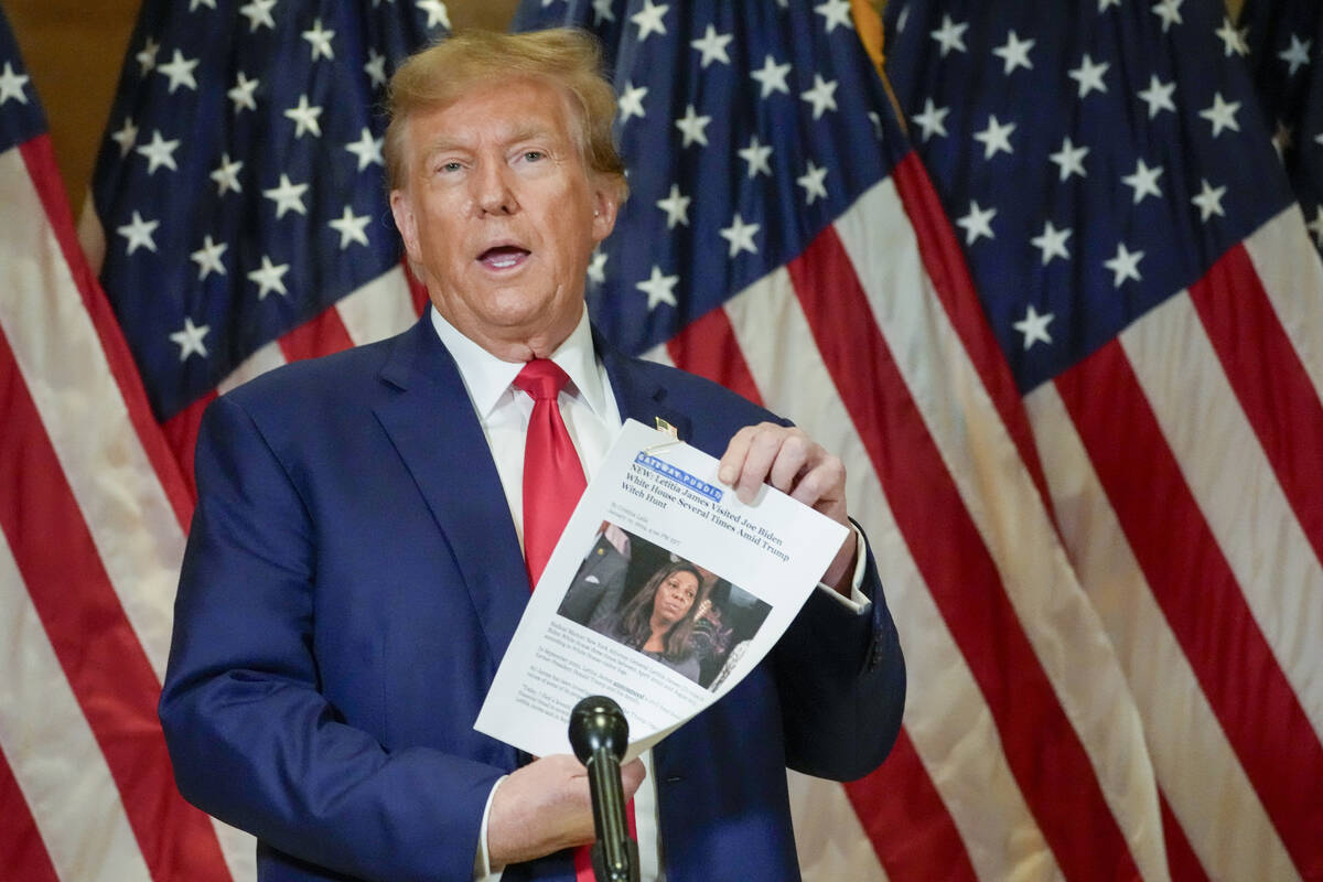 FILE - Former President Donald Trump holds up a copy of a story featuring New York Attorney Gen ...