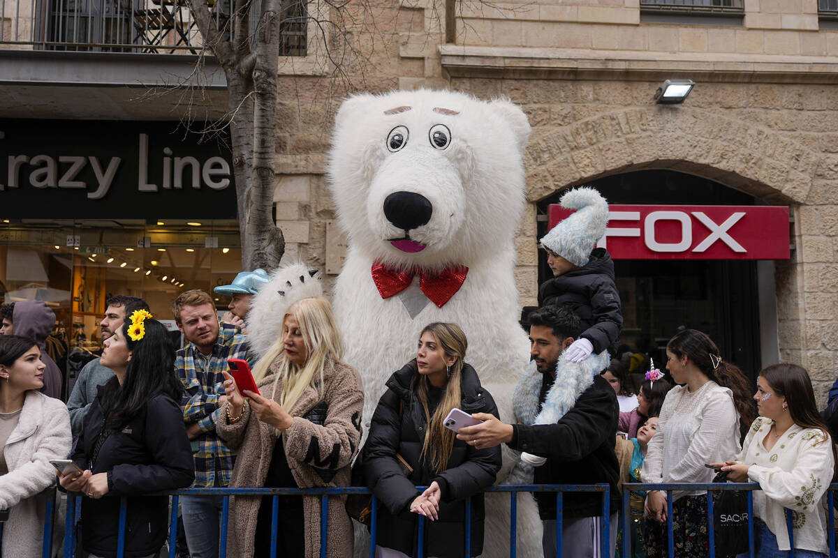 People watch the Purim parade in Jerusalem, Monday, March 25, 2024. Jerusalem held a Purim para ...