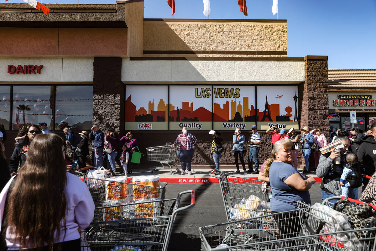 Customers line up to shop and line up for free food giveaways at Superior Grocers at the grand ...