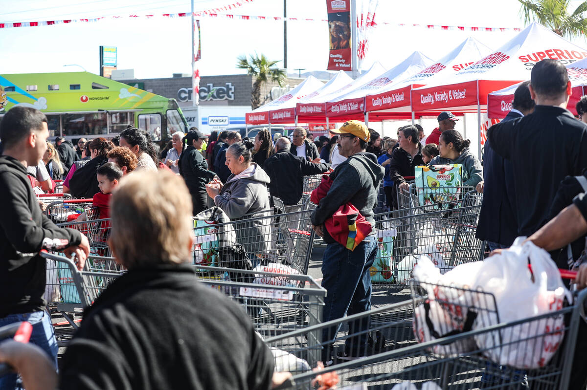 Customers line up for free food giveaways at Superior Grocers at the grand opening in East Las ...