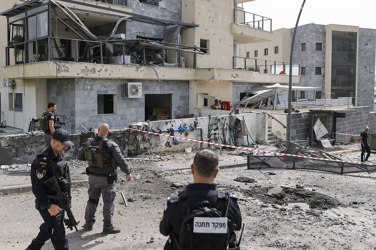 Israeli forces check a building that was hit by a Hezbollah rocket in Kiryat Shmona in northern ...