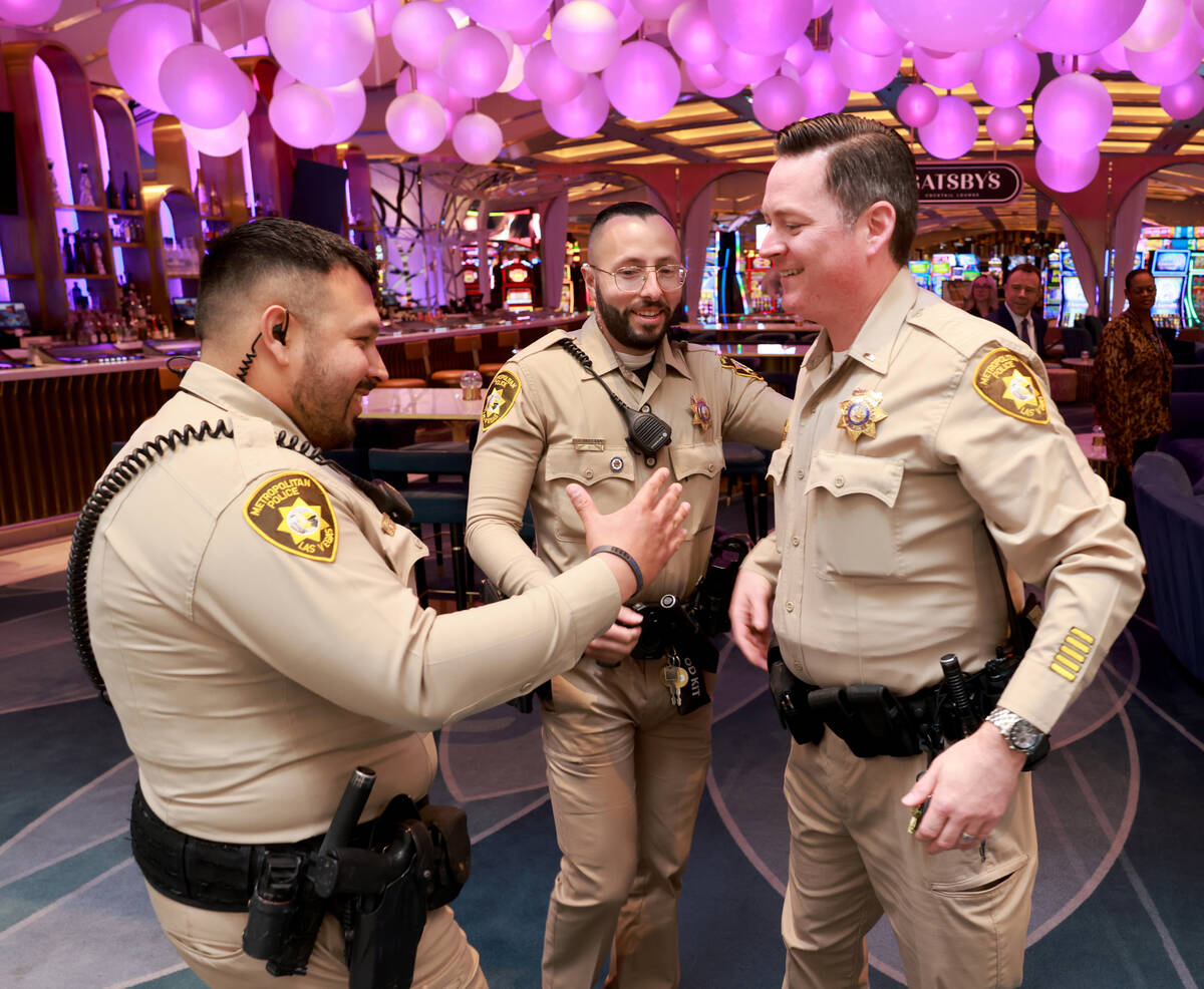 Las Vegas police officers Humberto Zarate, left, and Oscar Murguia, center, are greeted by Lt. ...