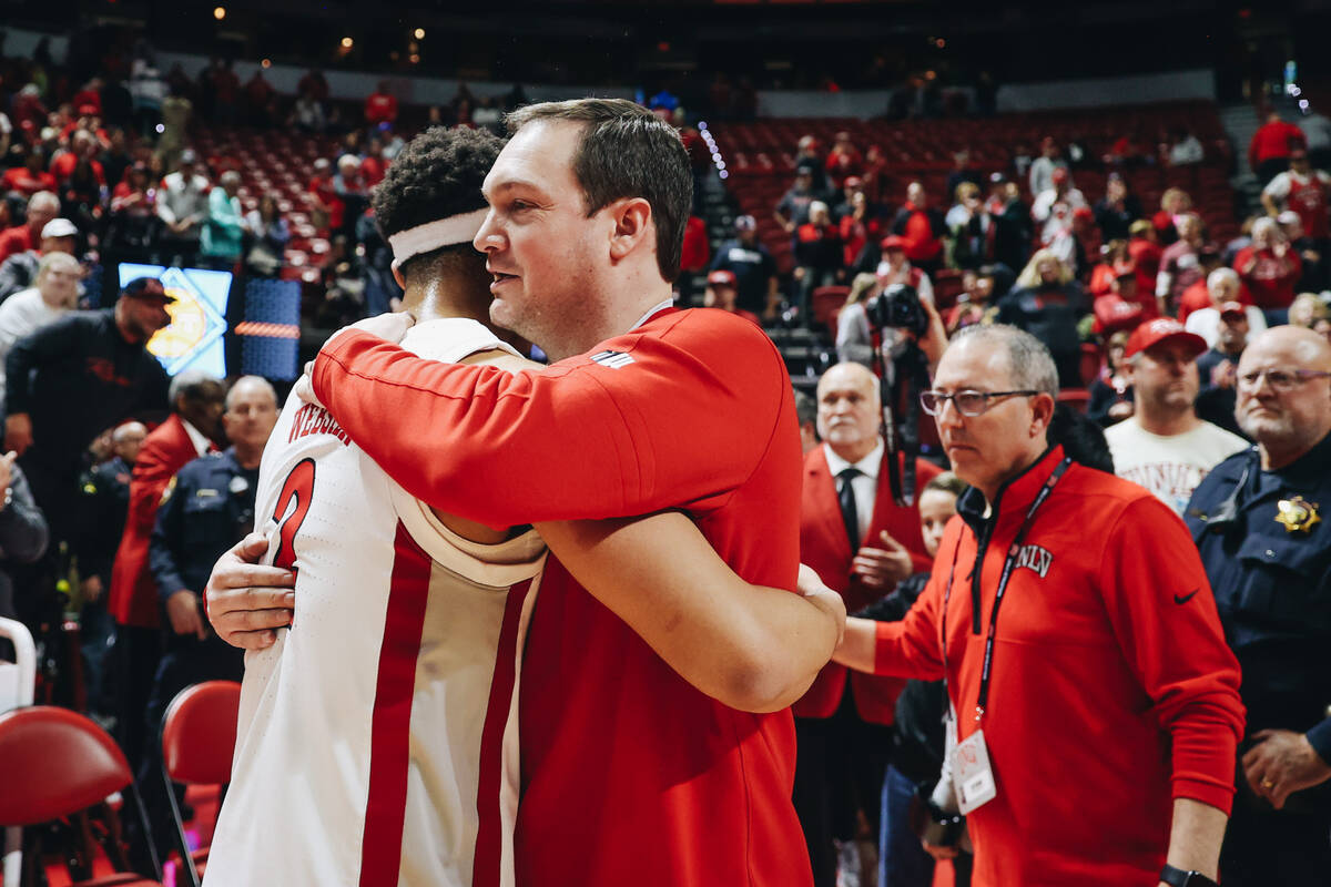 UNLV head coach Kevin Kruger hugs UNLV guard Justin Webster (2) after winning a second-round NI ...