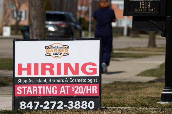A hiring sign is seen outside of a barber shop in Northbrook, Ill., Tuesday, March 12, 2024. On ...