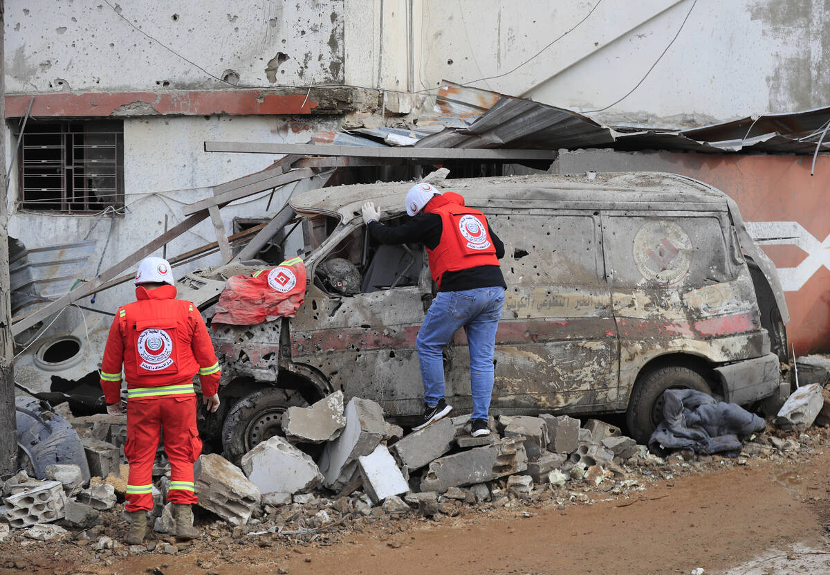 Paramedic workers check a damaged ambulance that parked outside of a paramedic center that was ...