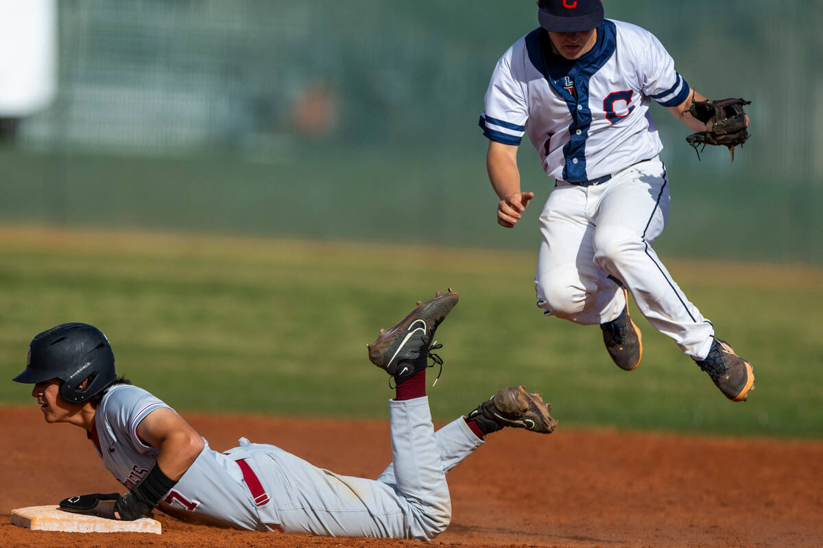 Desert Oasis runner Brody Griffith (7) gets to second base safely under a jumping grab by Coron ...