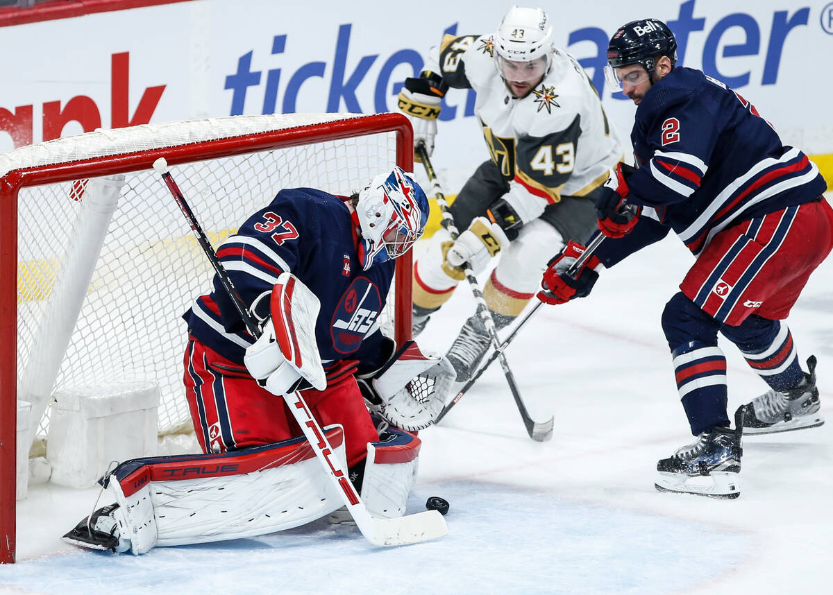 Winnipeg Jets goaltender Connor Hellebuyck (37) saves the shot from Vegas Golden Knights' Paul ...