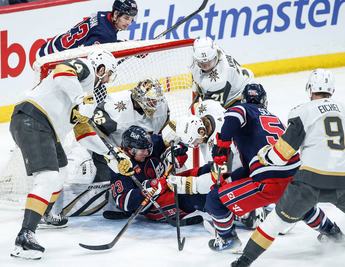 Winnipeg Jets' Tyler Toffoli (73) goes down on Vegas Golden Knights goaltender Logan Thompson's ...