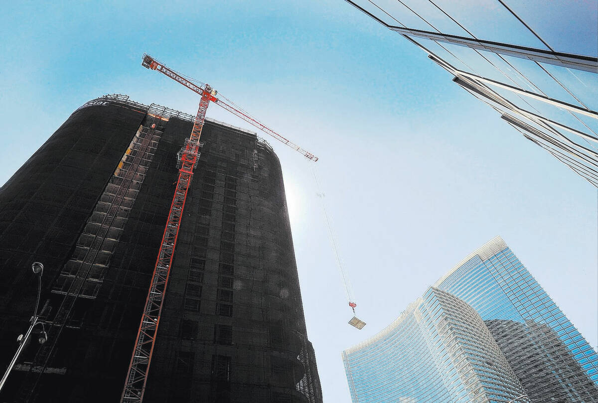 A tower crane lowers a concrete slab as the demolition continues of the unfinished Harmon Hotel ...