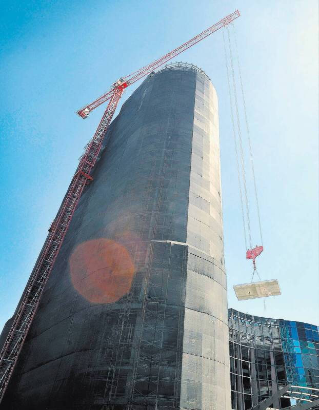 A tower crane lowers a concrete slab as the demolition continues of the unfinished Harmon Hotel ...