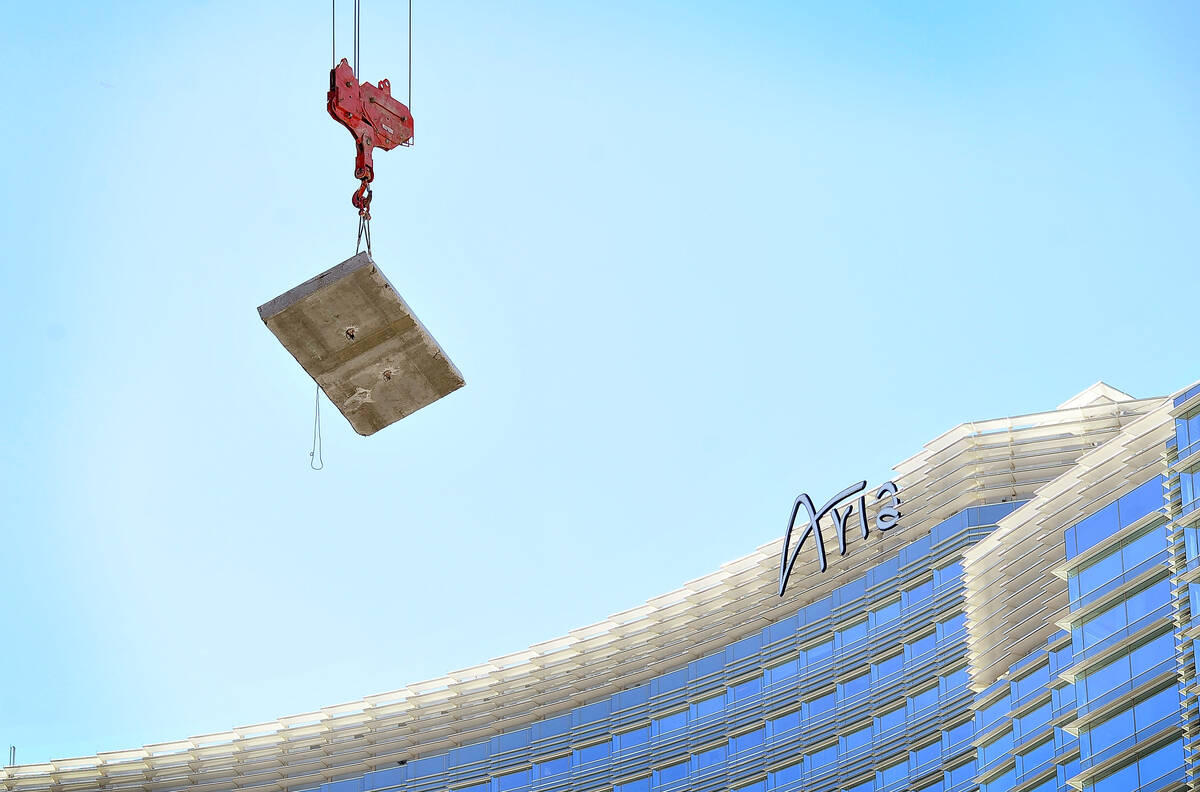 A tower crane lowers a concrete slab by the Aria hotel-casino as the demolition continues of th ...