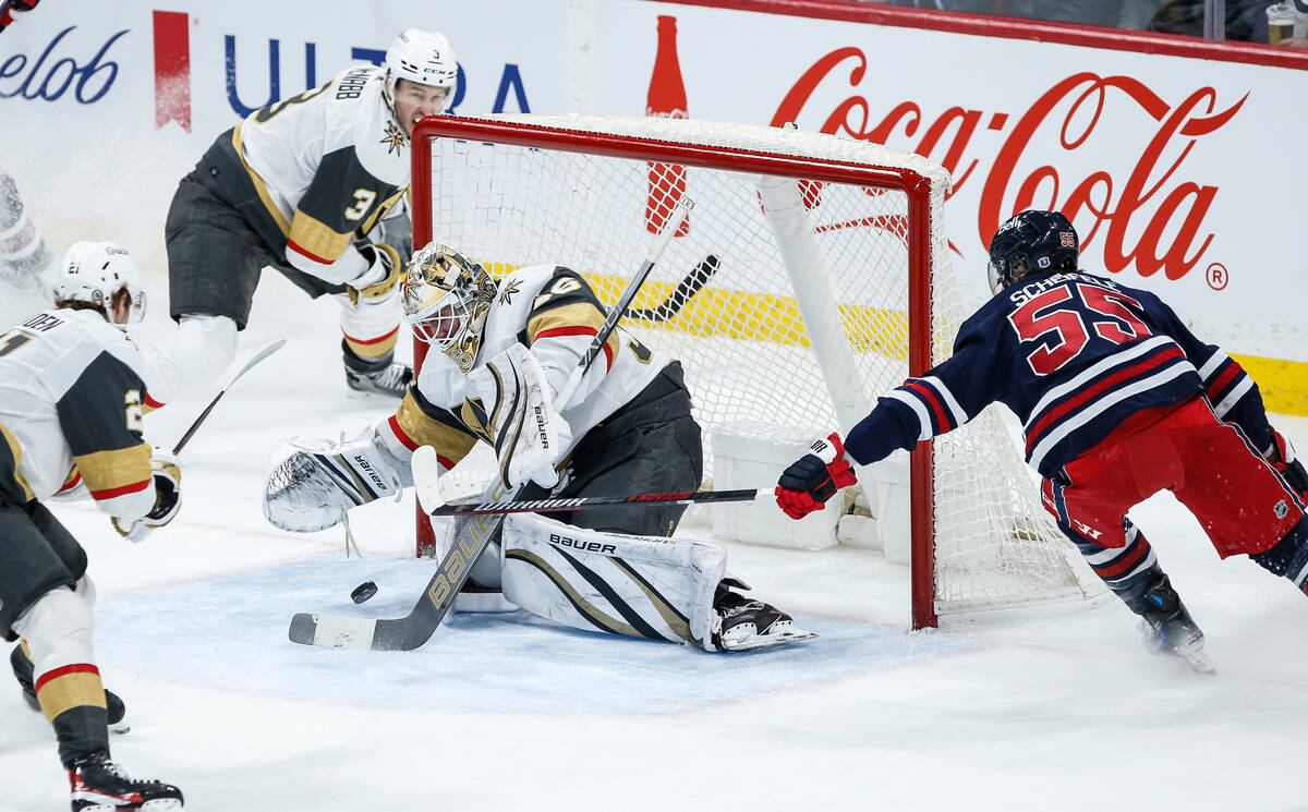 Vegas Golden Knights goaltender Logan Thompson saves a shot from Winnipeg Jets' Mark Scheifele ...