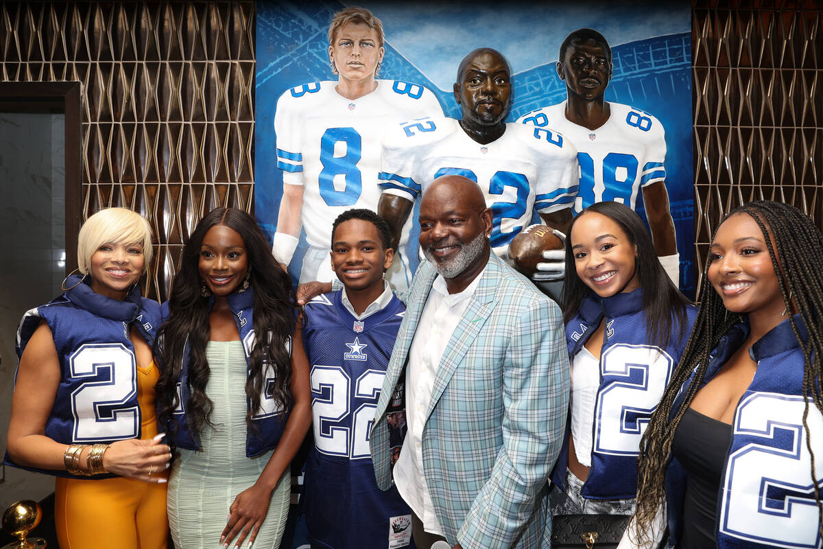 NFL legend and restaurant founder Emmitt Smith, center right, poses with his family in front of ...