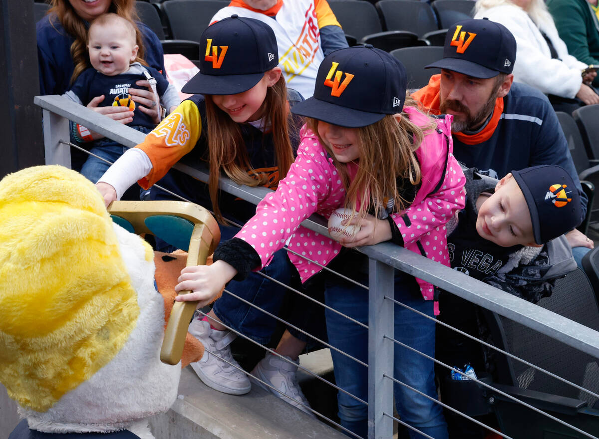 Ciela Rodarte, 8, left, and her sister Carina, 6, place a giant sunglasses on Aviators mascot S ...