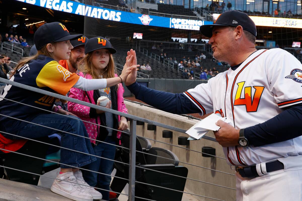 Aviators Manager Fran Riordan high fives Ciela Rodarte, 8, as her sister Carina, 6, looks on pr ...