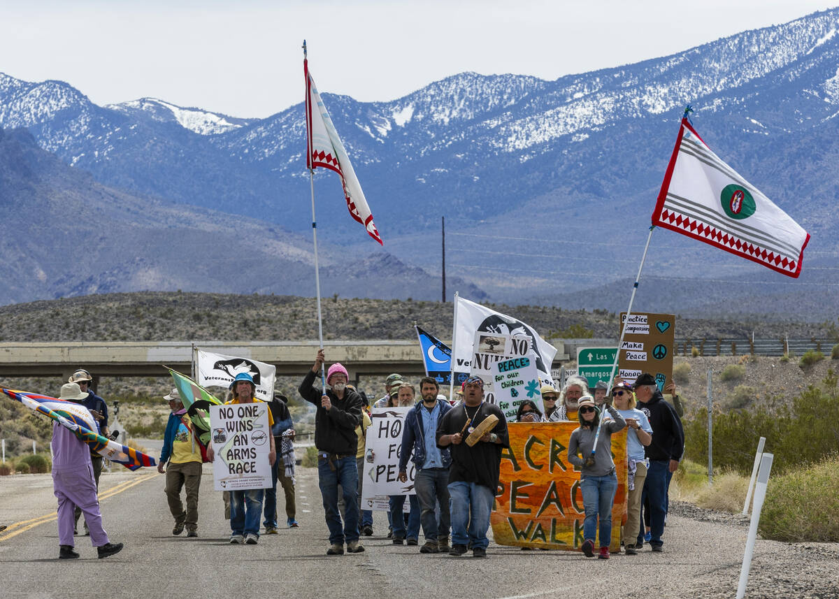 Members of the Nevada Desert Experience sacred peace walk make their way down to the entry of t ...