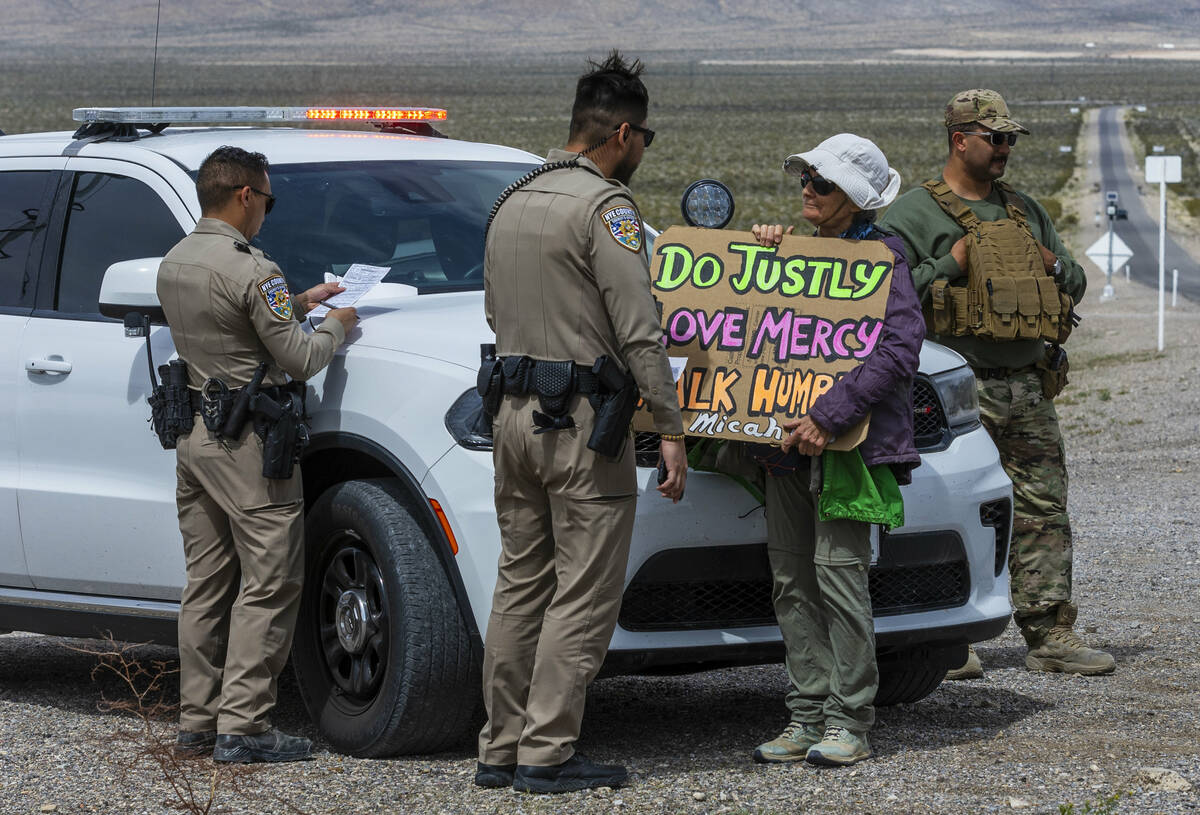 Beth Blattenberger, center, stands beside officers awaiting a citation after trespassing onto t ...