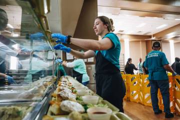 Volunteers help serve up an annual Easter meal at the Las Vegas Rescue Mission on Friday, March ...