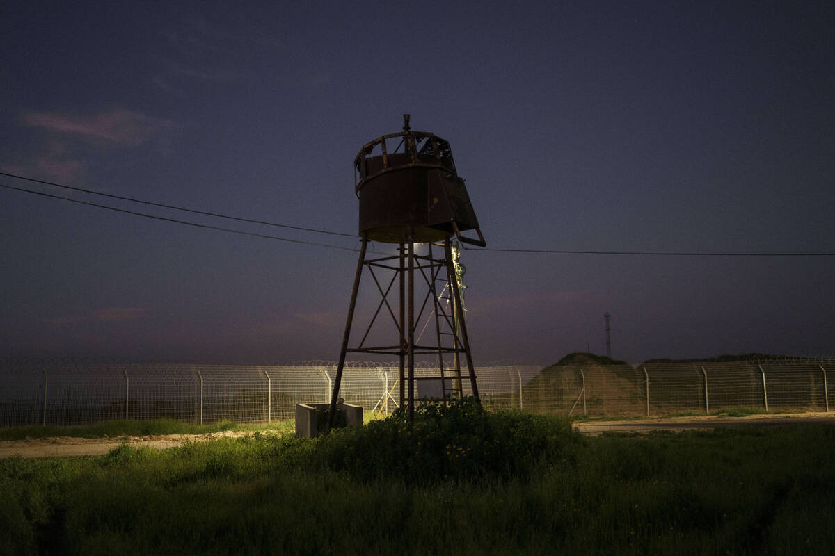 An old observation tower stands near the fence of Kibbutz Nahal Oz, Israel, Wednesday, Feb. 28, ...