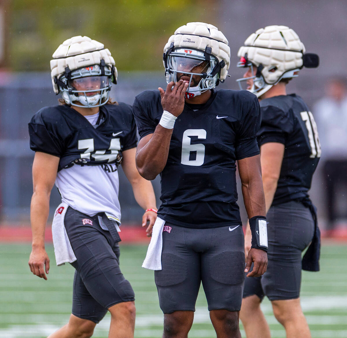 UNLV quarterback Hajj-Malik Williams (6), center, licks his hand flanked by quarterbacks Gael O ...