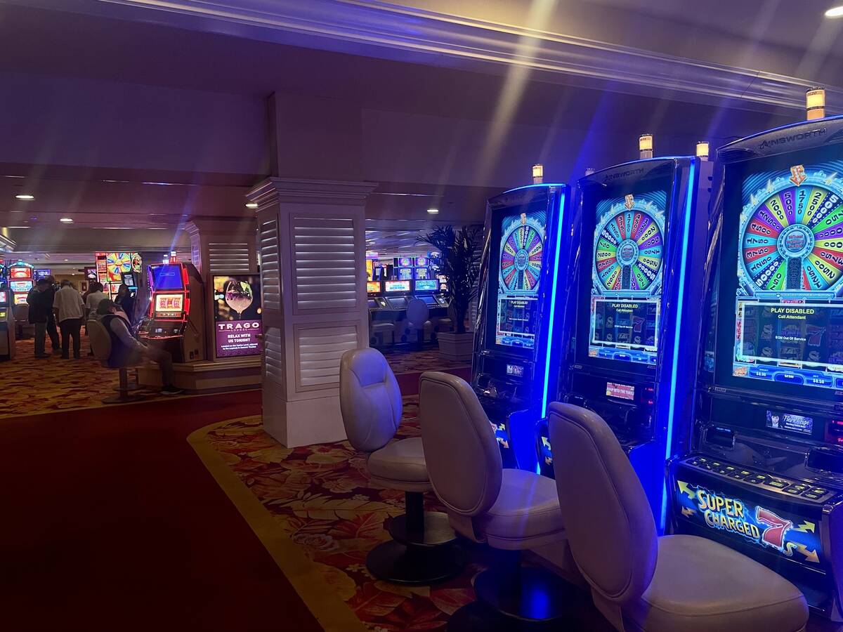 Players sit at available slot machines while others are decommissioned at the Tropicana on Satu ...