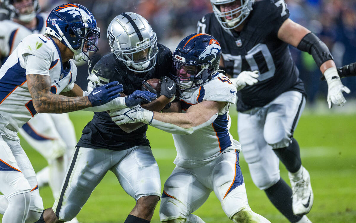 Raiders running back Zamir White (35) fights to get to the end zone against Denver Broncos corn ...