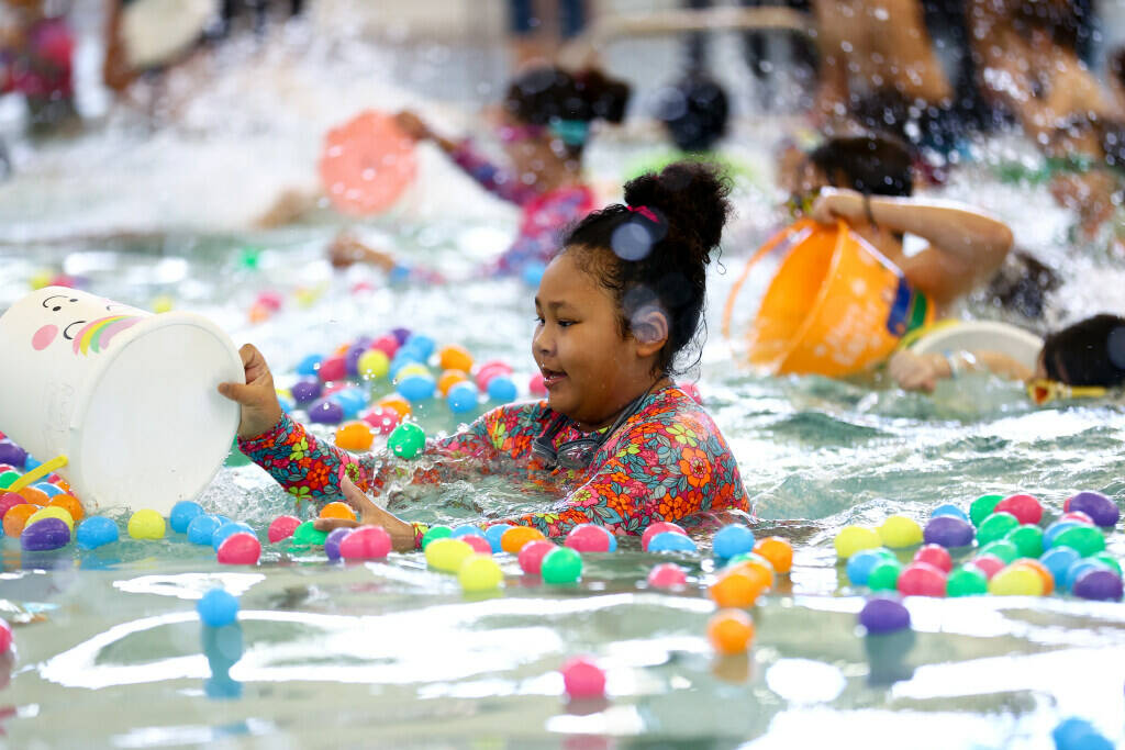 Ruby Lineberger, 8, dives into the pool for prizes during an Easter egg dive at Heritage Park A ...