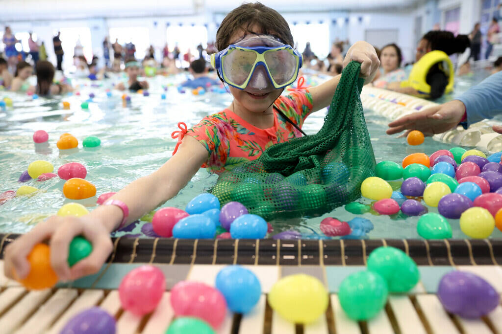 Isabella Rose, 10, fills her bag with loot during an Easter egg dive at Heritage Park Aquatic C ...