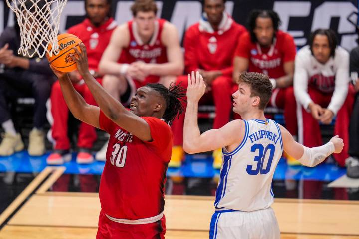 North Carolina State's DJ Burns Jr., left, goes up for a basket against Duke's Kyle Filipowski ...