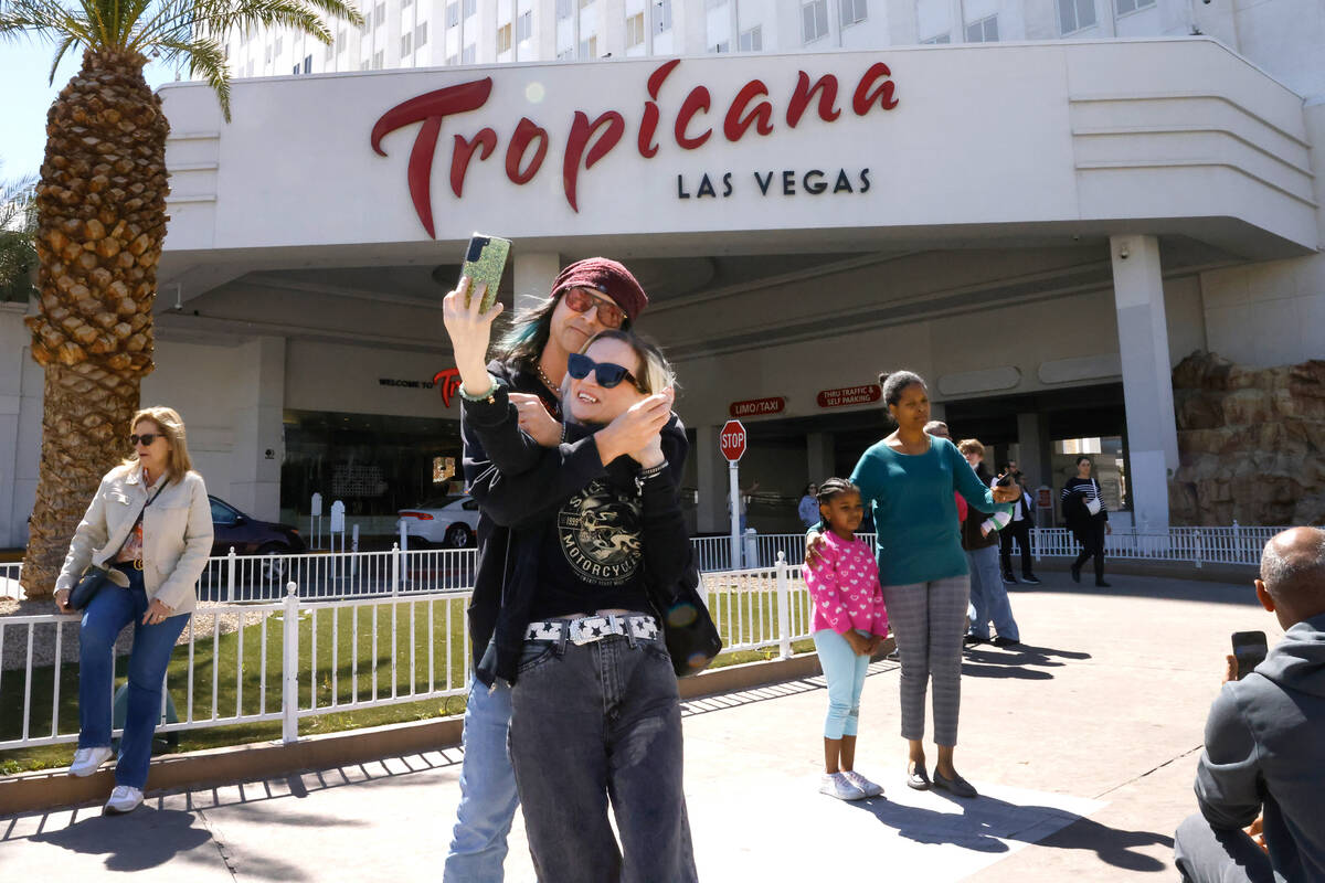 People, including Todd Osterhouse of Texas and his girlfriend Sarah, pose for a photo in front ...