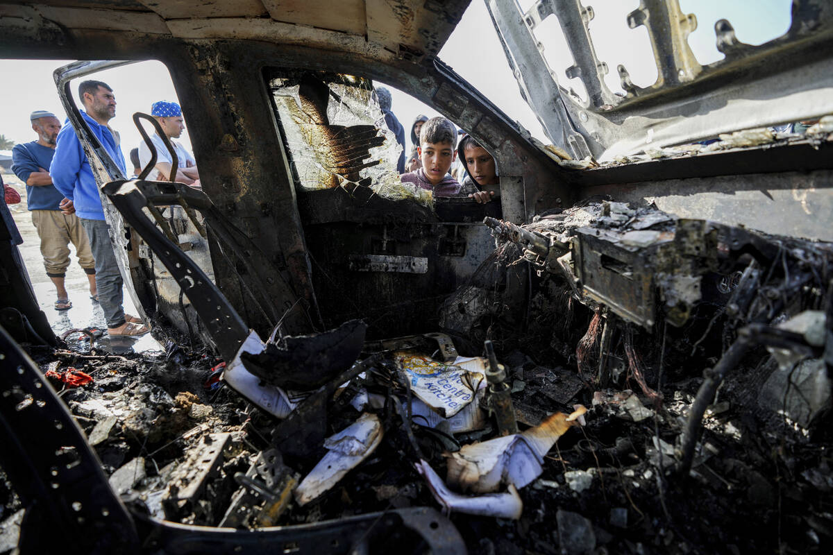 People inspect the site where World Central Kitchen workers were killed in Deir al-Balah, Gaza ...