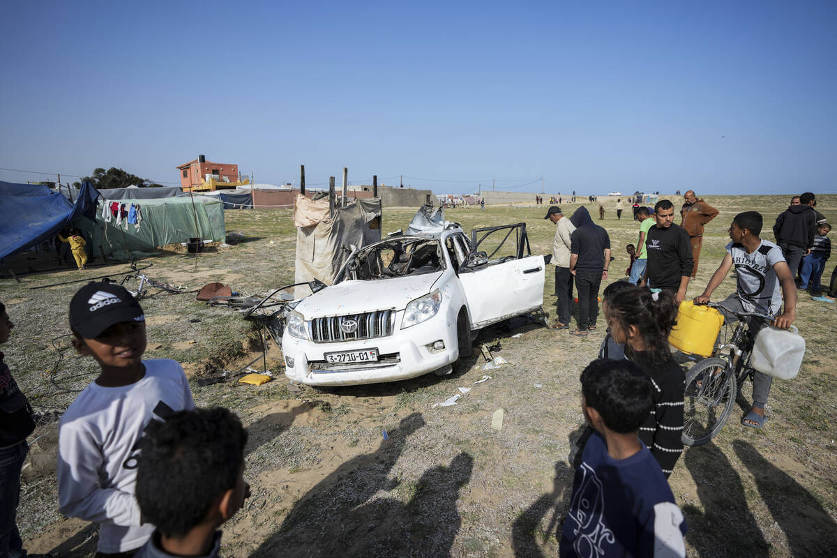 People inspect the site where World Central Kitchen workers were killed in Deir al-Balah, Gaza ...