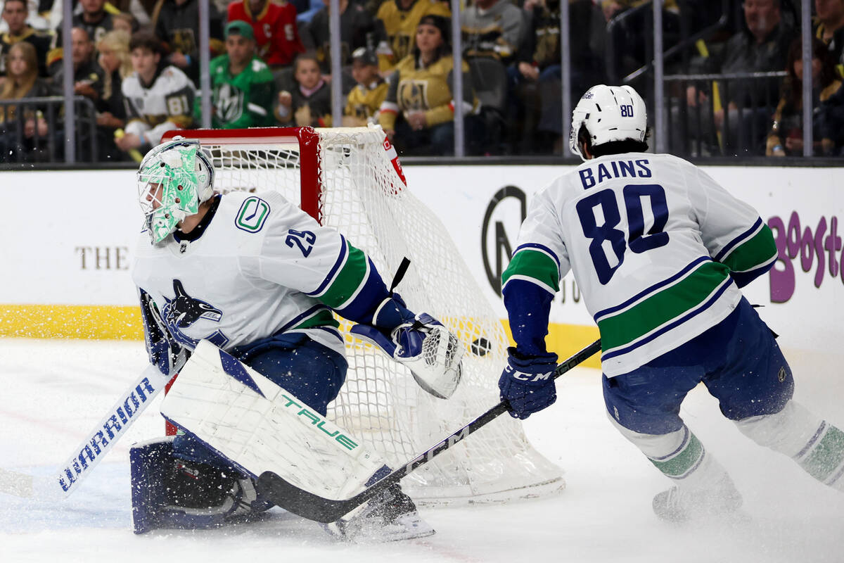 The puck hits the back of the net behind Canucks goaltender Casey DeSmith (29) during the first ...