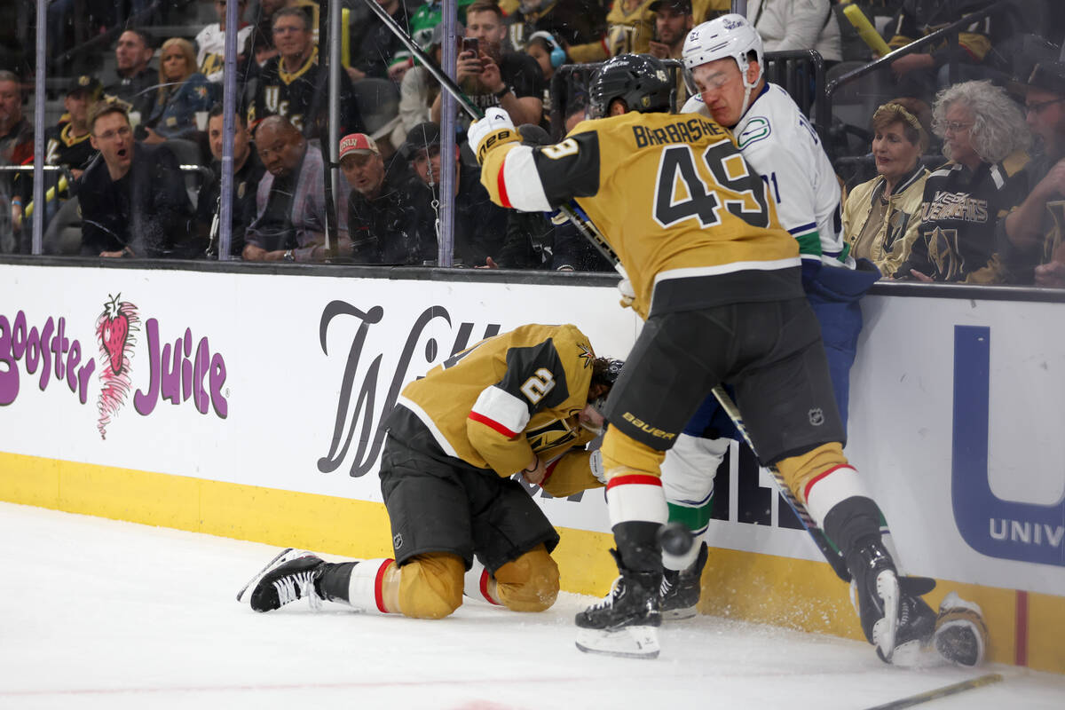 Golden Knights center Brett Howden (21) reacts on the ice after taking a hit from Canucks defen ...