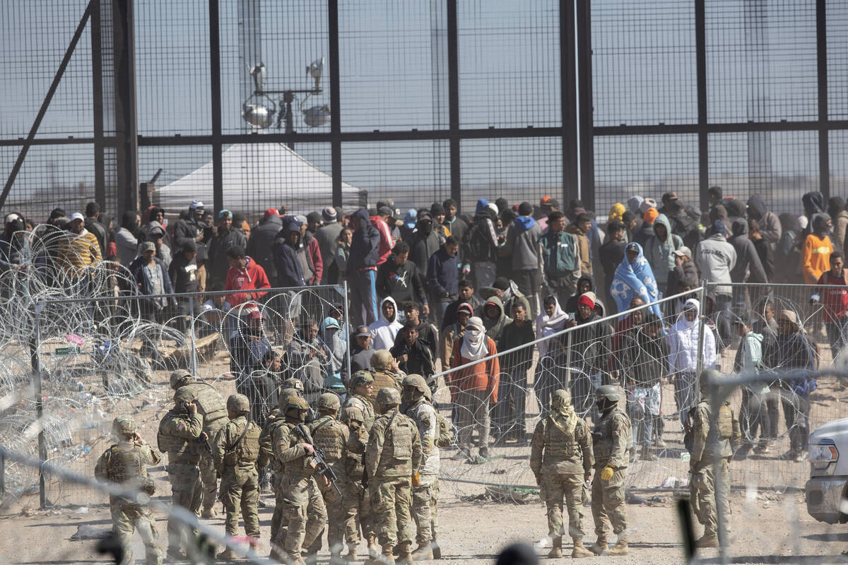 Migrants who breached the barriers set up on the Rio Grande in El Paso, Texas, by Texas Nationa ...