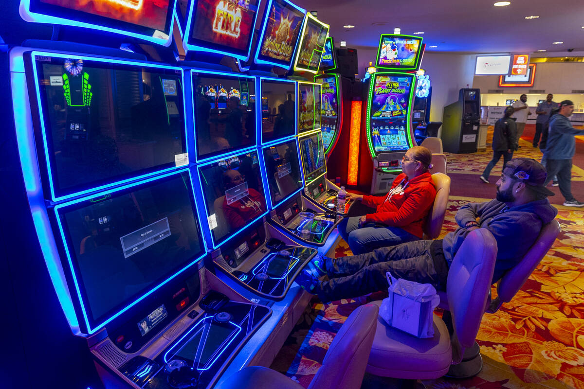 Ana and Julio Rendon play one of the few remaining slot machines as most about them are shut do ...