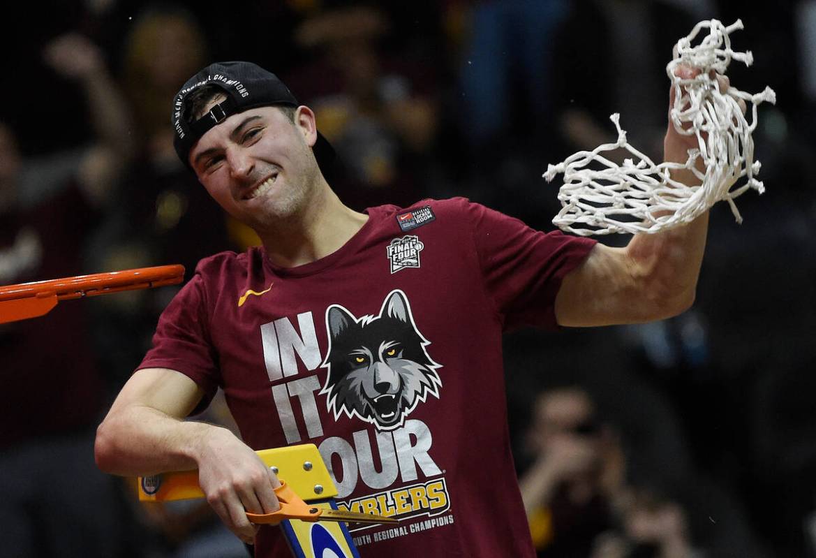 Loyola-Chicago guard Ben Richardson holds the net after a regional final NCAA college basketbal ...