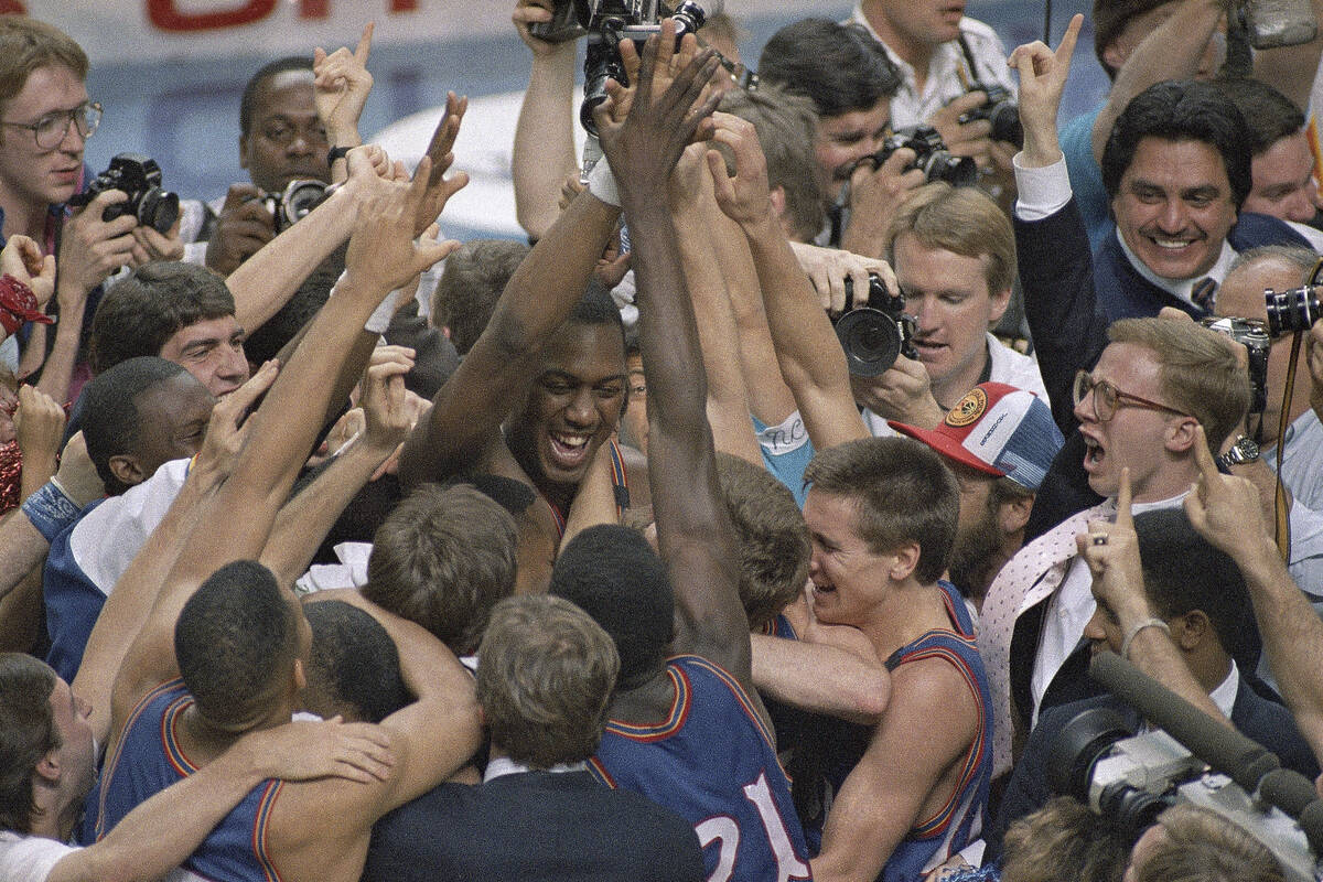 FILE - Kansas' Danny Manning, facing camera left of center, is mobbed by fans and teammates aft ...