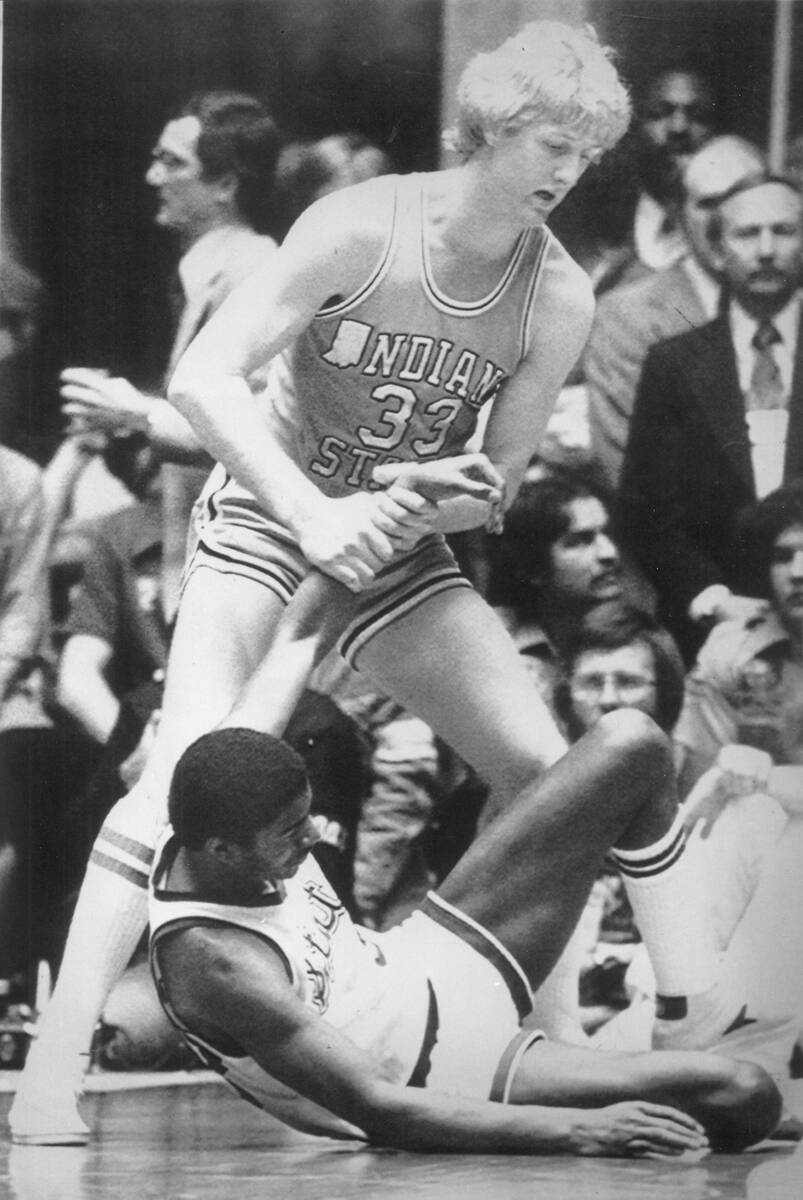 Indiana State's Larry Bird (33), gives a helping hand to a fallen Magic Johnson of Michigan Sta ...