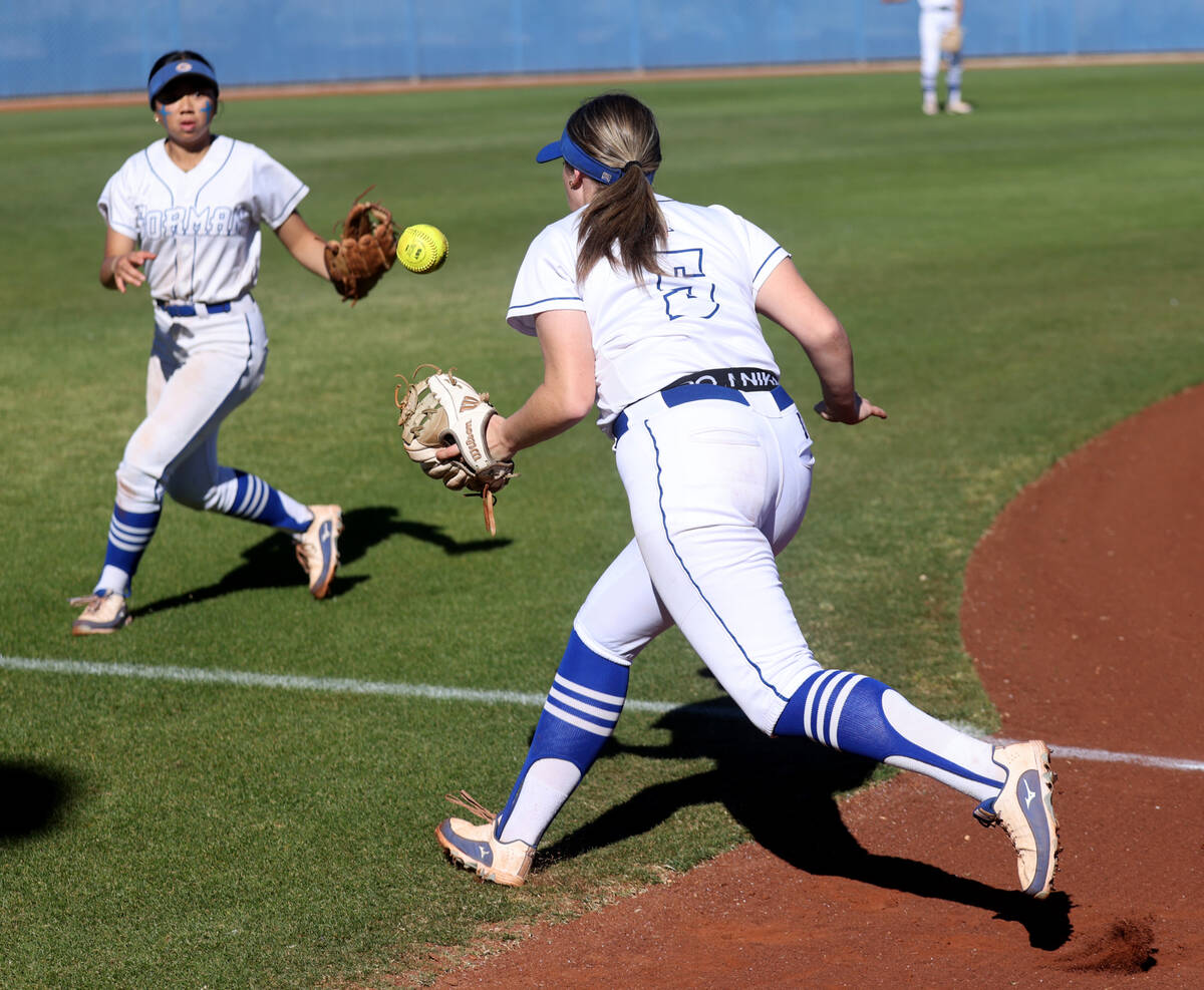 Bishop Gorman’s Allie Bernardo (3) and Samantha Lefever (5) look to field a fair ball ag ...