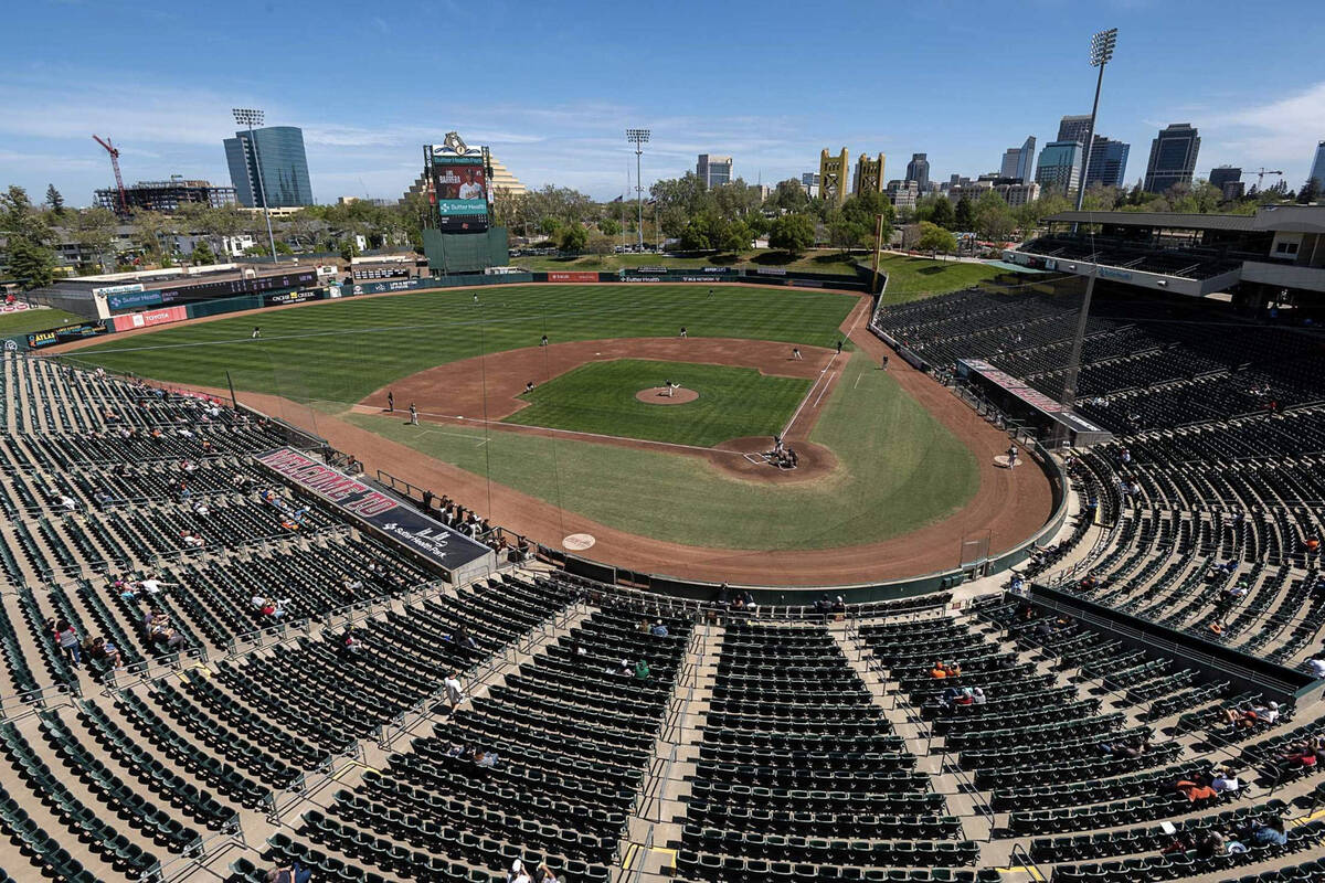 Baseball fans sit watch an exhibition game between the San Francisco Giants and Oakland A's at ...