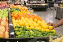 A customer grabs a lemon while browsing through produce during the grand opening of Albertsons ...