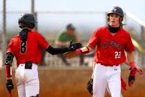 Las Vegas’ Bryden Bull (22) high fives Gage McCown after scoring a run during a high sch ...