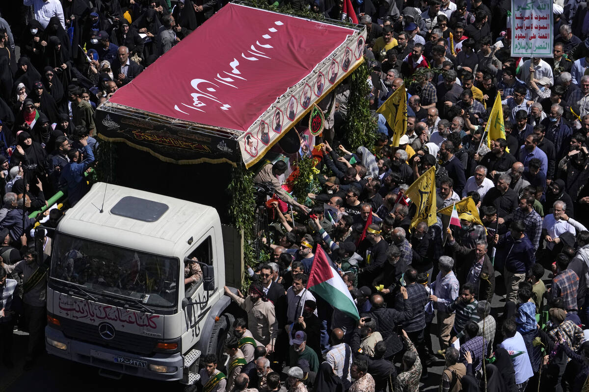 Iranian mourners gather around a truck carrying the coffins of Revolutionary Guard members kill ...
