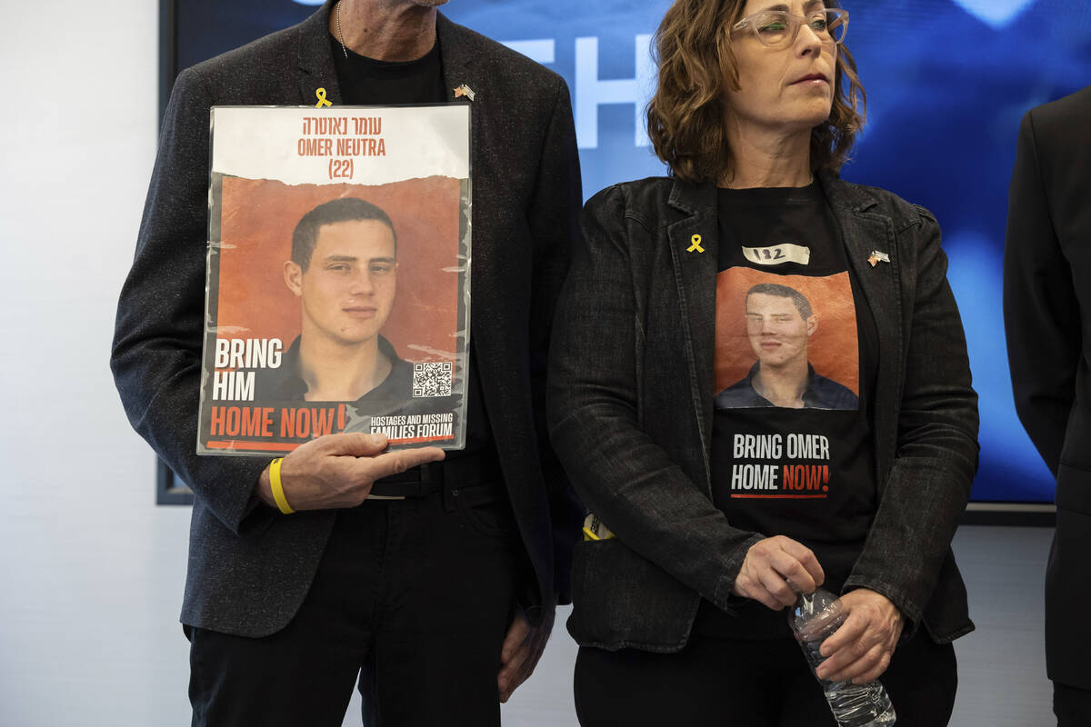 Ronen and Orna Neutra, parents of American hostage Omer Neutra, hold signs of their son during ...
