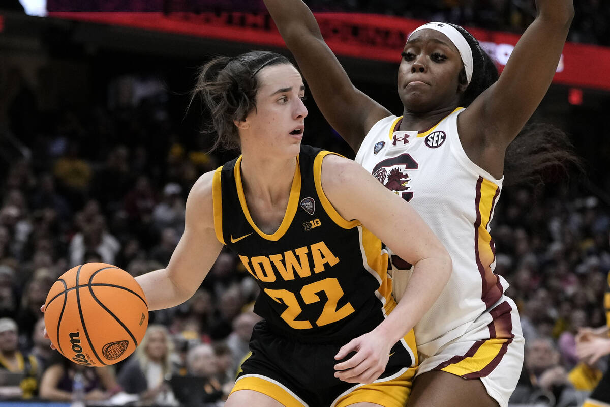 Iowa guard Caitlin Clark (22) drives around South Carolina guard Raven Johnson (25) during the ...