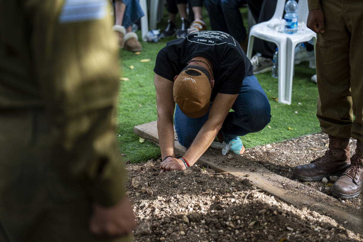 Avraham Harush, father of Israeli solider Sergeant Reef Harush, mourns over his grave in Ramat ...